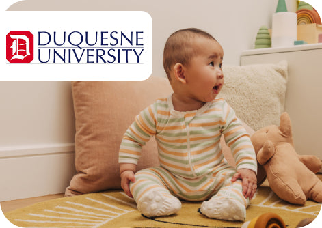 Baby sitting on a couch with toys, featuring Duquesne University logo.