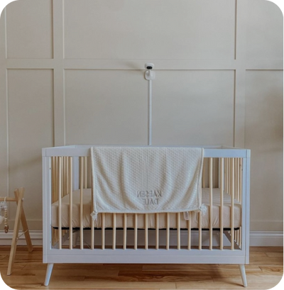Crib with nanit pro camera and wall mount in background