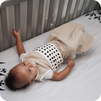 baby in crib wearing nanit breathing band in white
