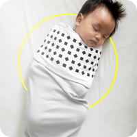 baby in nanit breathing wear swaddle in white