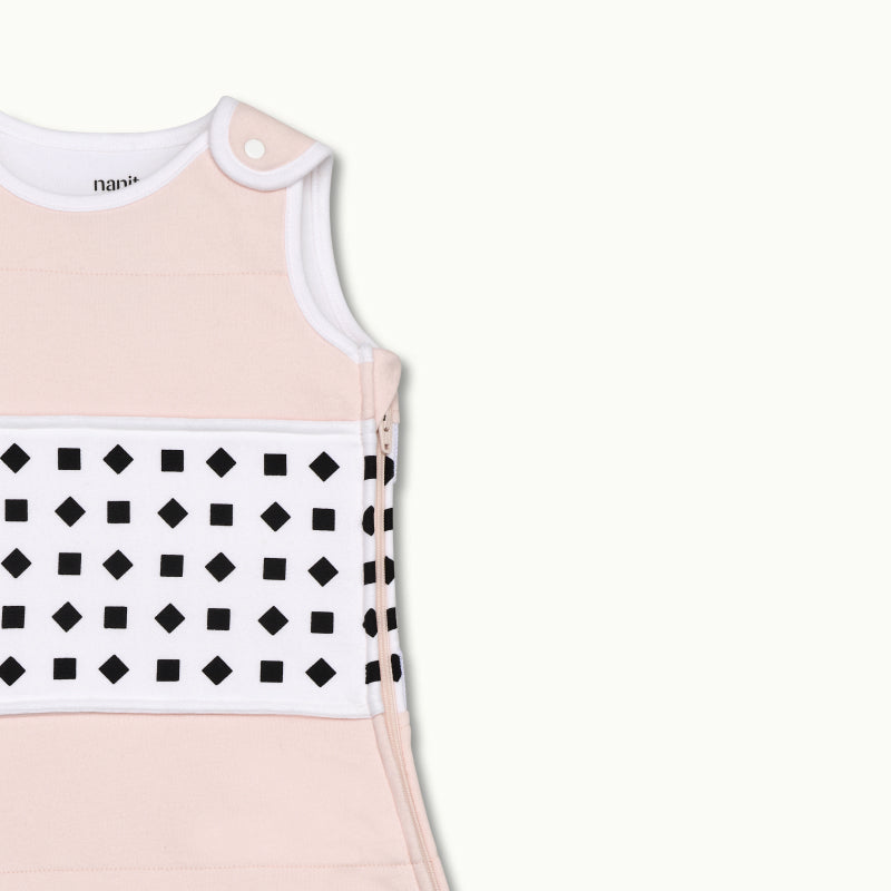 nanit blush pink sleeping bag shown zoomed in on shoulder button and zipped up on side