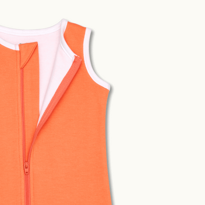 zoomed in on nickel-free snap tab zipper cover, plus protective chin zipper guard on sleeping bag in cantaloupe