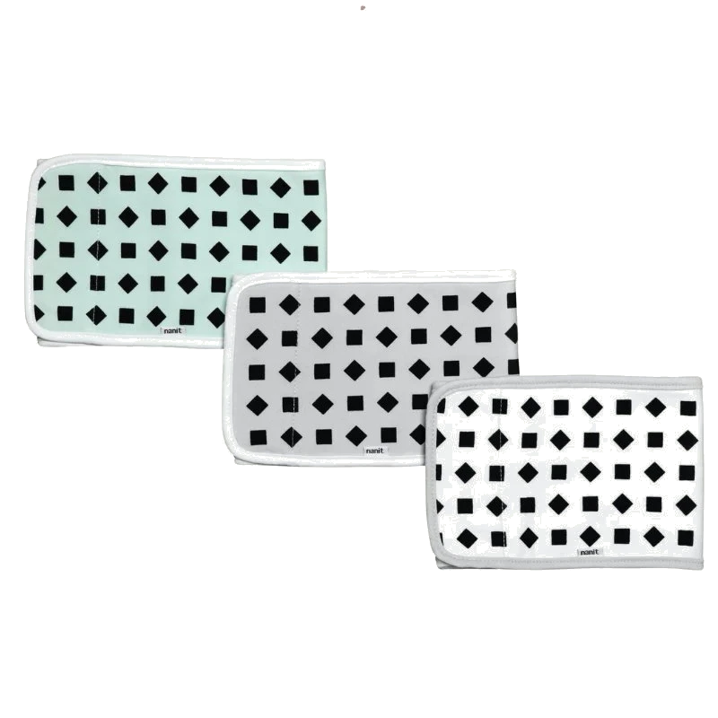 Three folded rectangular cloths with black geometric patterns—squares and diamonds—on white or light mint backgrounds, each bordered with white trim, arranged in a staggered row