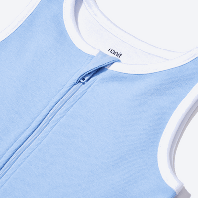 zoomed in on nickel-free snap tab zipper cover, plus protective chin zipper guard on sleeping bag in cornflower blue