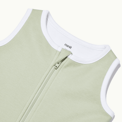 zoomed in on nickel-free snap tab zipper cover, plus protective chin zipper guard on sleeping bag in pistachio