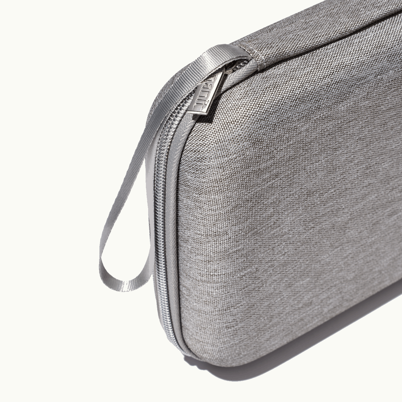 zoomed in picture of gray zipper and strap on gray travel case #color_gray