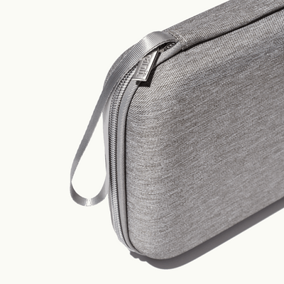 zoomed in picture of gray zipper and strap on gray travel case