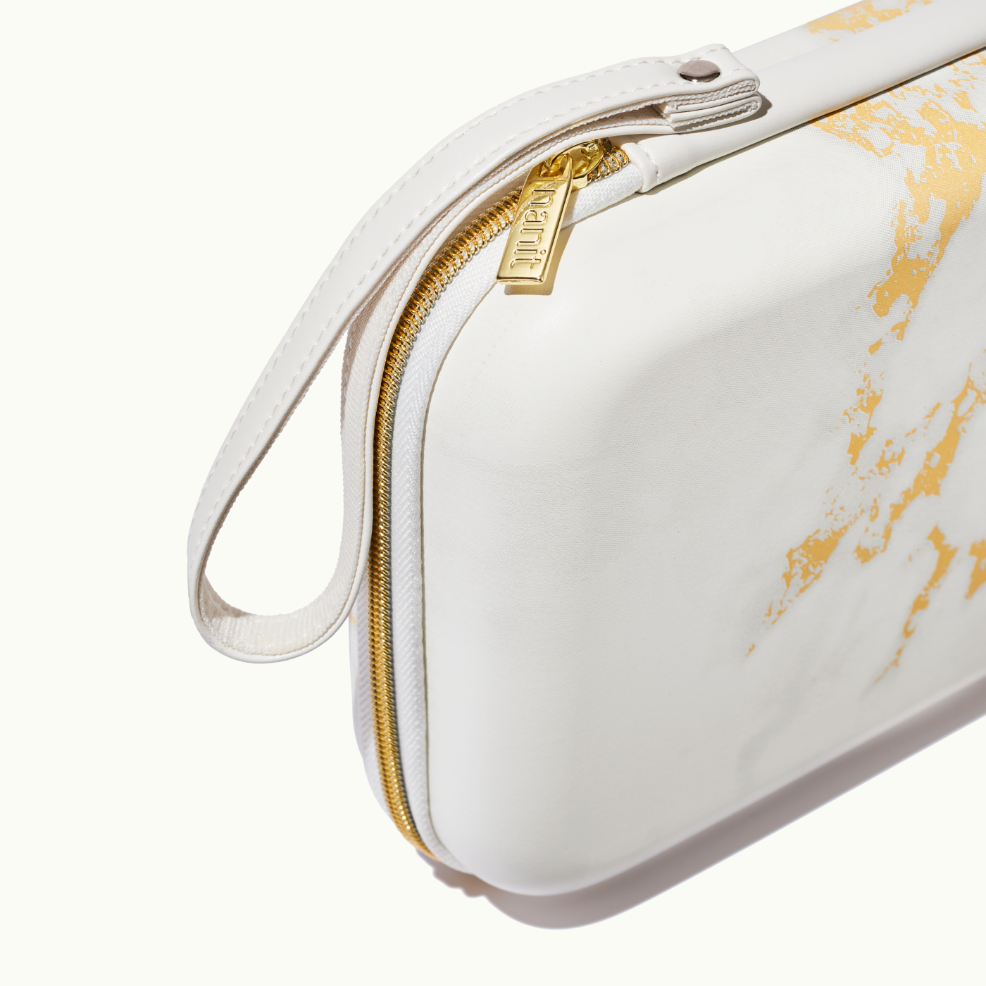 zoomed in picture of gold zipper and strap on marble travel case