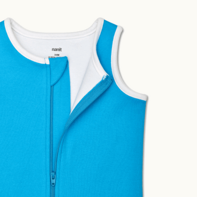 zoomed in on nickel-free snap tab zipper cover, plus protective chin zipper guard on sleeping bag in tropical blue