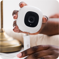 Person holding a pro baby monitor on one hand and flex stand on the other