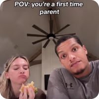 first time parents' image with girl eating sandwich and man looking at camera