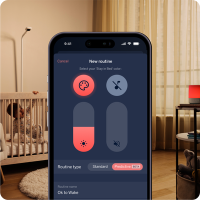 A smartphone displaying a "New routine" on nanit app interface in a dimly lit room with a crib. A baby stands in the crib, visually engaging with the scene.