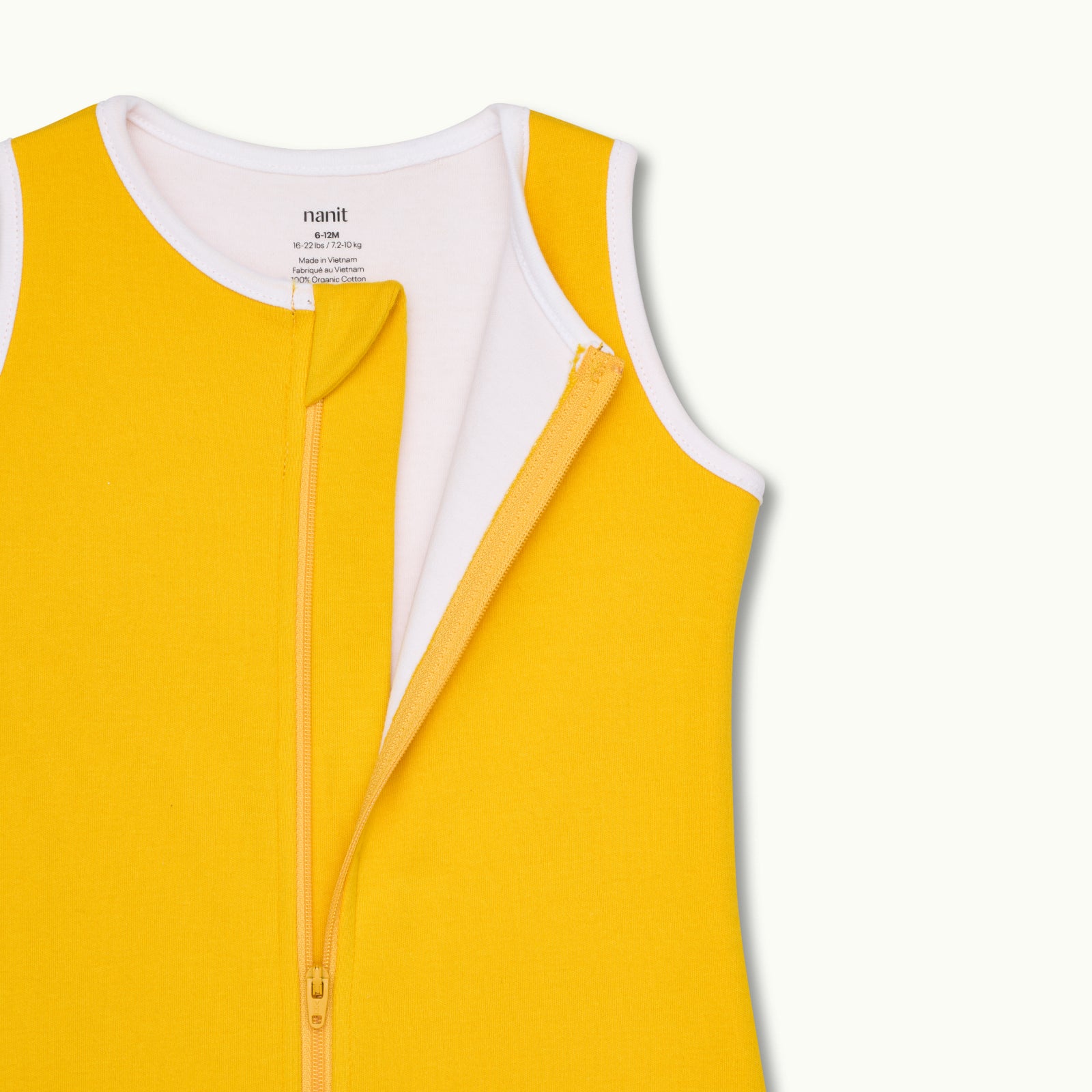 zoomed in on nickel-free snap tab zipper cover, plus protective chin zipper guard on sleeping bag in marigold #color_marigold