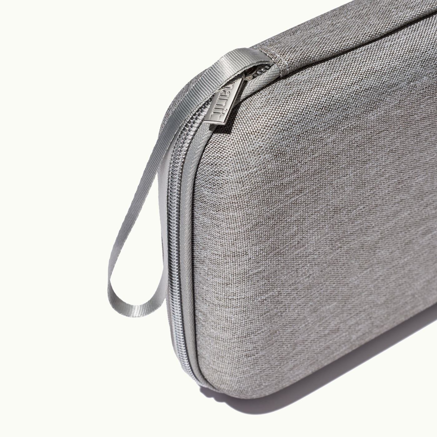 zoomed in picture of gray zipper and strap on gray travel case #color_gray