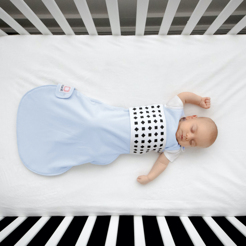 baby sleeping in crib while wearing nanit powder blue breathing wear sleeping bag #color_powder blue