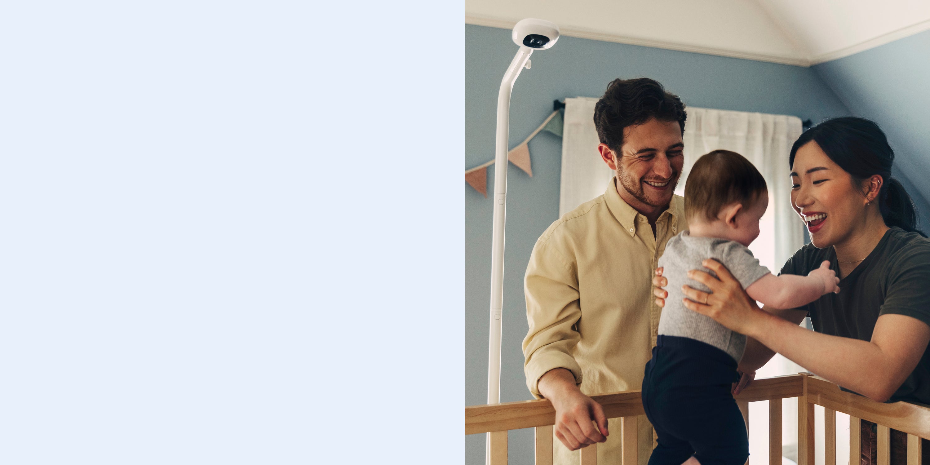 Family in a nursery with a baby monitor on a wall.