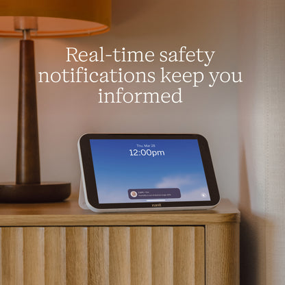 Nanit Home on a wooden cabinet with text about real-time safety notifications.