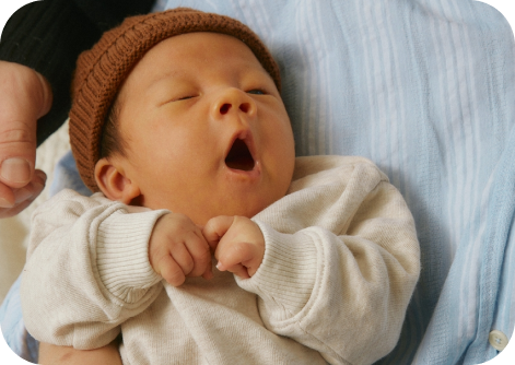 baby yawning wear hat and pajamas 