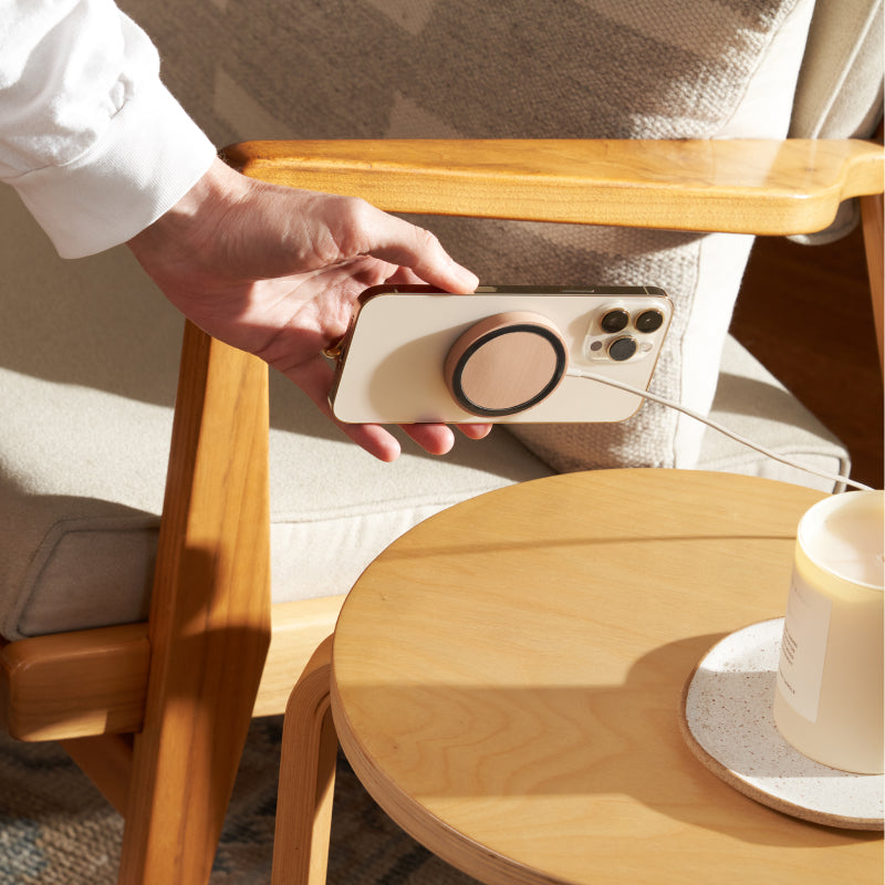 woman grabbing iPhone on courant mag:1 essentials charger in camel