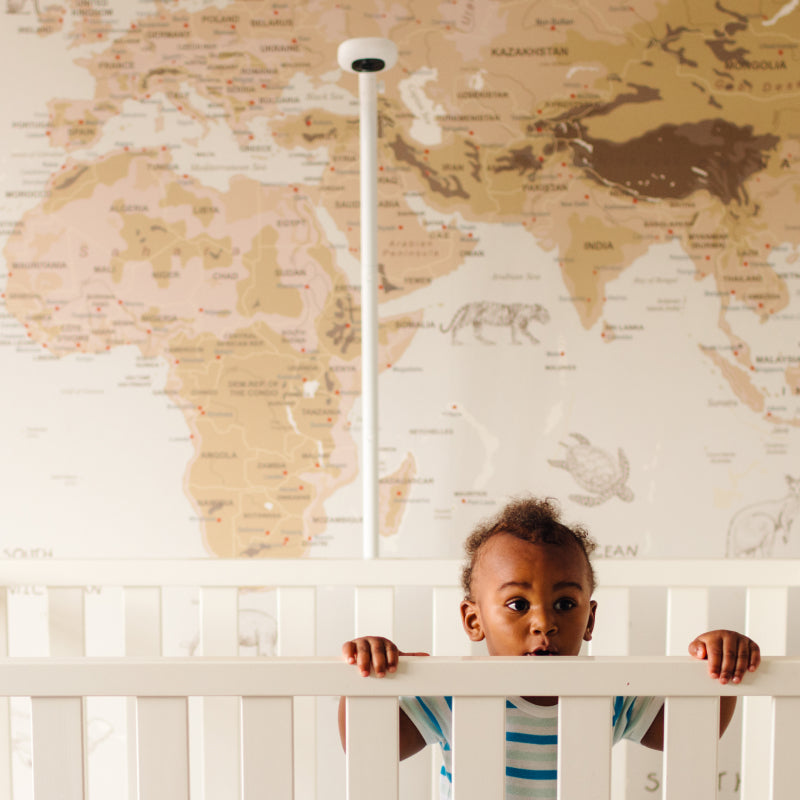 baby in crib with nanit pro camera + floor stand behind