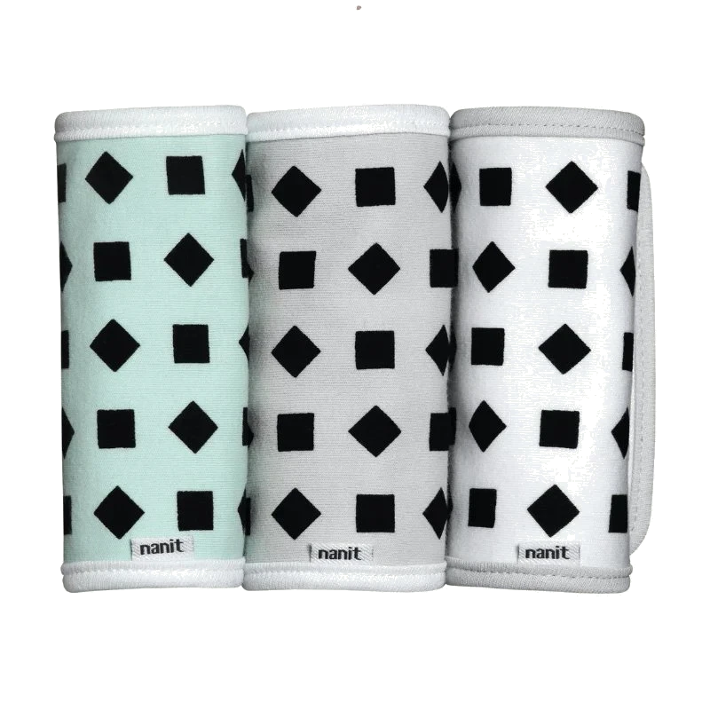 Three cylindrical products with geometric pattern packaging on a white background, branded 'nanit' 