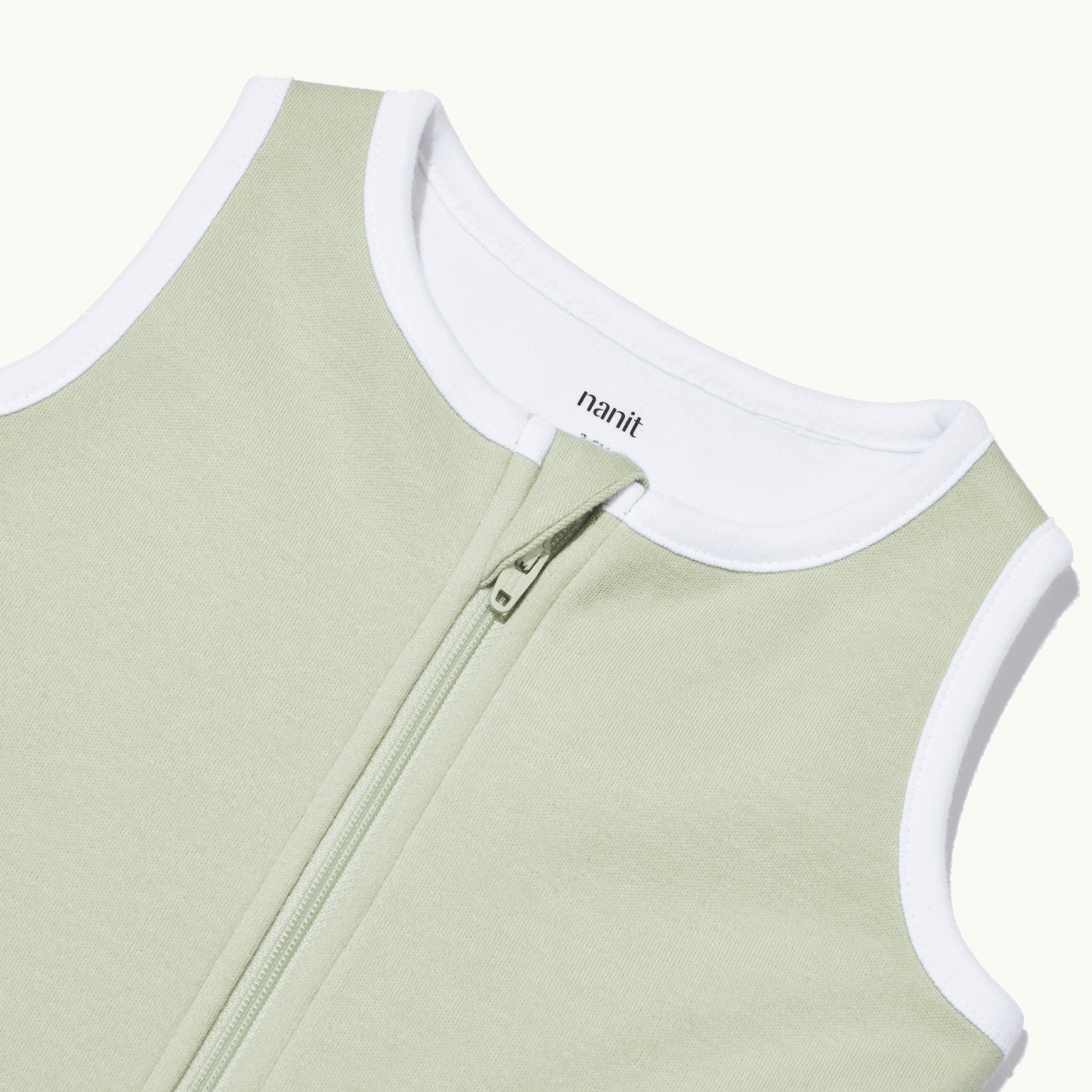 zoomed in on nickel-free snap tab zipper cover, plus protective chin zipper guard on sleeping bag in pistachio #color_pistachio