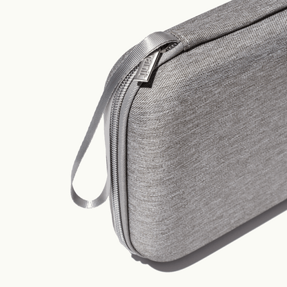 zoomed in picture of gray zipper and strap on gray travel case 