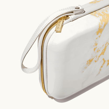 zoomed in picture of gold zipper and strap on marble travel case 