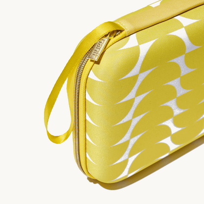 zoomed in picture of gold zipper and strap on yellow travel case 