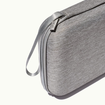 zoomed in picture of gray zipper and strap on gray travel case 