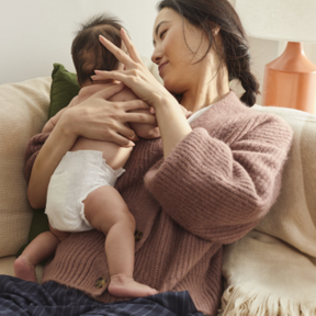 Baby wearing Coterie diaper while mom holding her baby