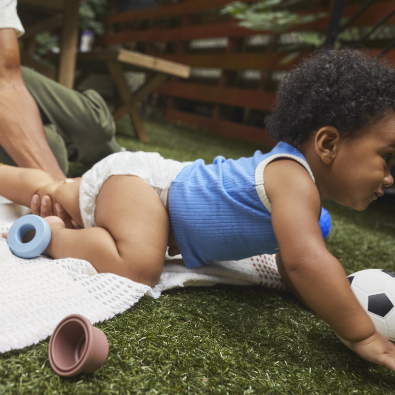 Baby crawling and wearing Coterie Diaper