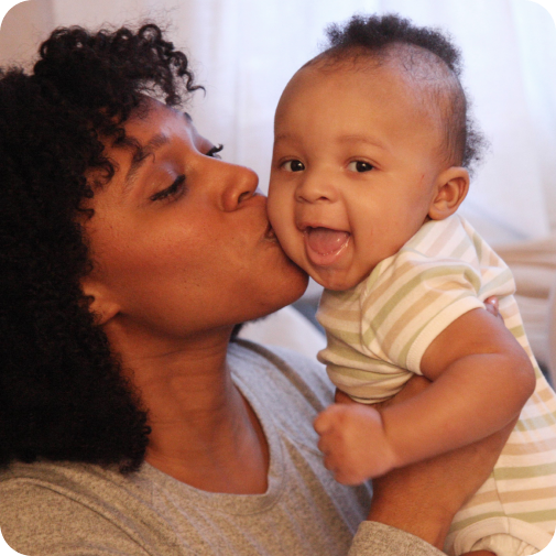 Mom holding and kissing baby