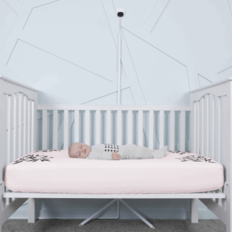 baby sleeping in nanit pajamas in crib covered in pink smart sheet with nanit pro and clearance floor stand in front of crib #color_pink