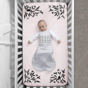 baby wearing nanit breathing wear sleeping bag laying on crib with pink smart sheet covered #color_pink