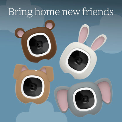 Four cute animal-shaped baby monitors with ears and eyes, shown in brown bear, tan dog, white rabbit, and gray elephant designs on a blue cloud-patterned background with the text 'Bring home new friends'.