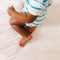 Baby sitting on Nanit Knit Crib Sheet in pink sunburst