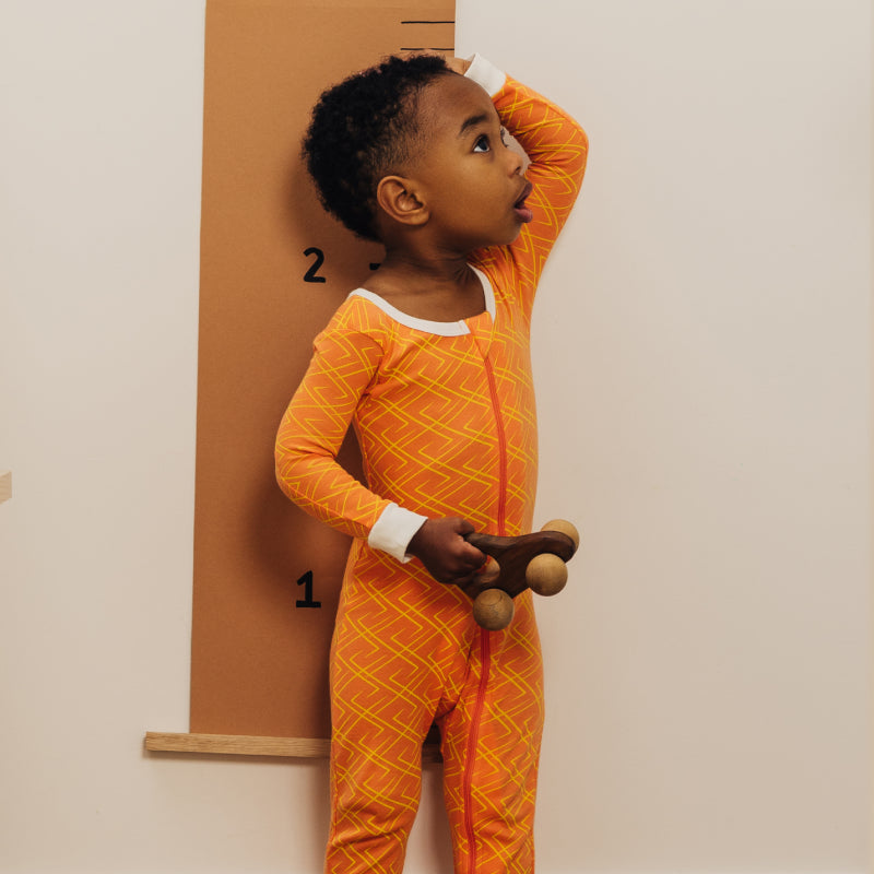 Toddler wearing Nanit Sleep Wear Pajamas in Go Between color