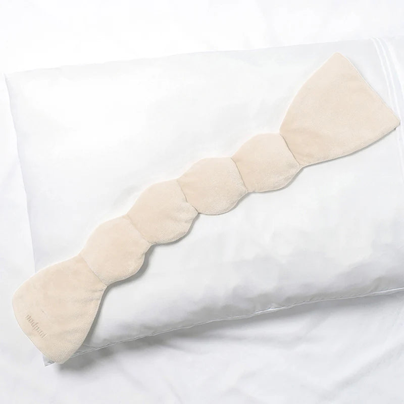 nodpod sleep mask in beige color on top of pillow