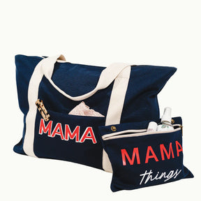 mama weekender bag with hair clip and other items inside with "mama things" pouch on the side with items