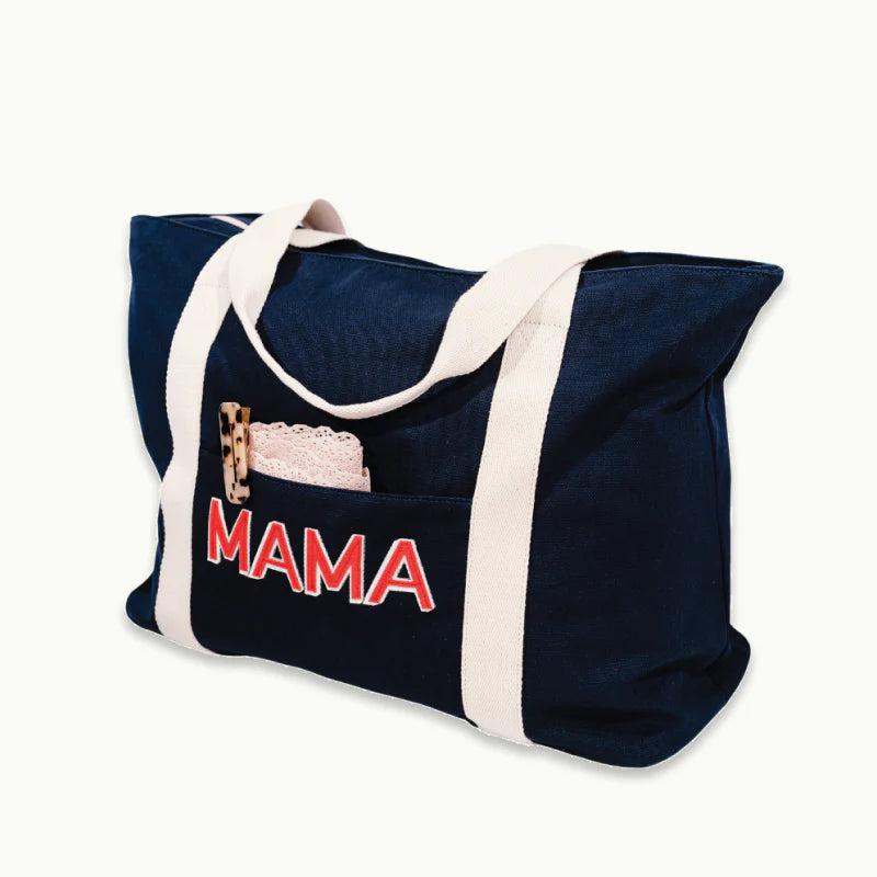 ingrid + isabel mama weekender bag with hair clip and other items inside