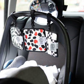 Etta Loves Sensory Hanging Squares 3-Pack hanging on baby car seat rail
