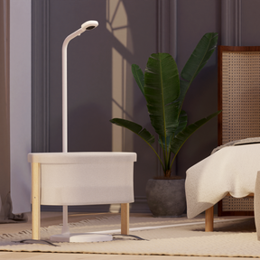 nanit pro camera + floor stand placed in front of small crib in bedroom 