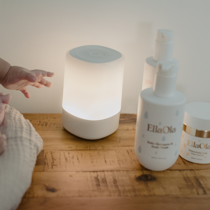baby hand trying to reach for sound and light on next to ellaola products