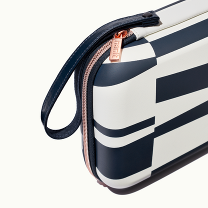zoomed in picture of rose pink zipper and strap on abstract stripe travel case 