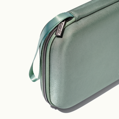 zoomed in picture of gray zipper and strap on green travel case 