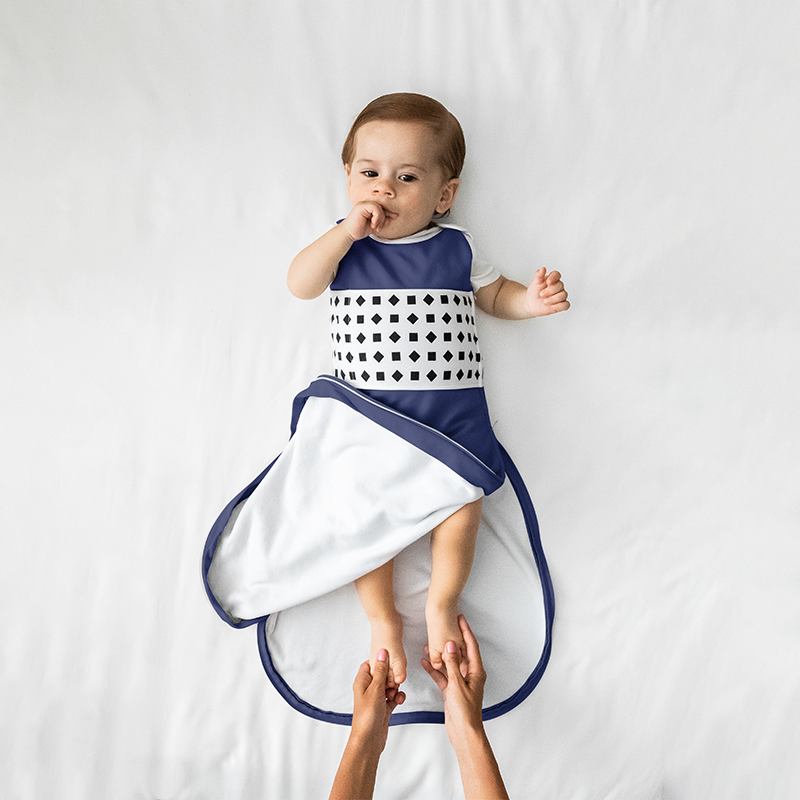 baby wearing nanit midnight blue breathing wear sleeping bag with bottom unzipped #color_midnight blue
